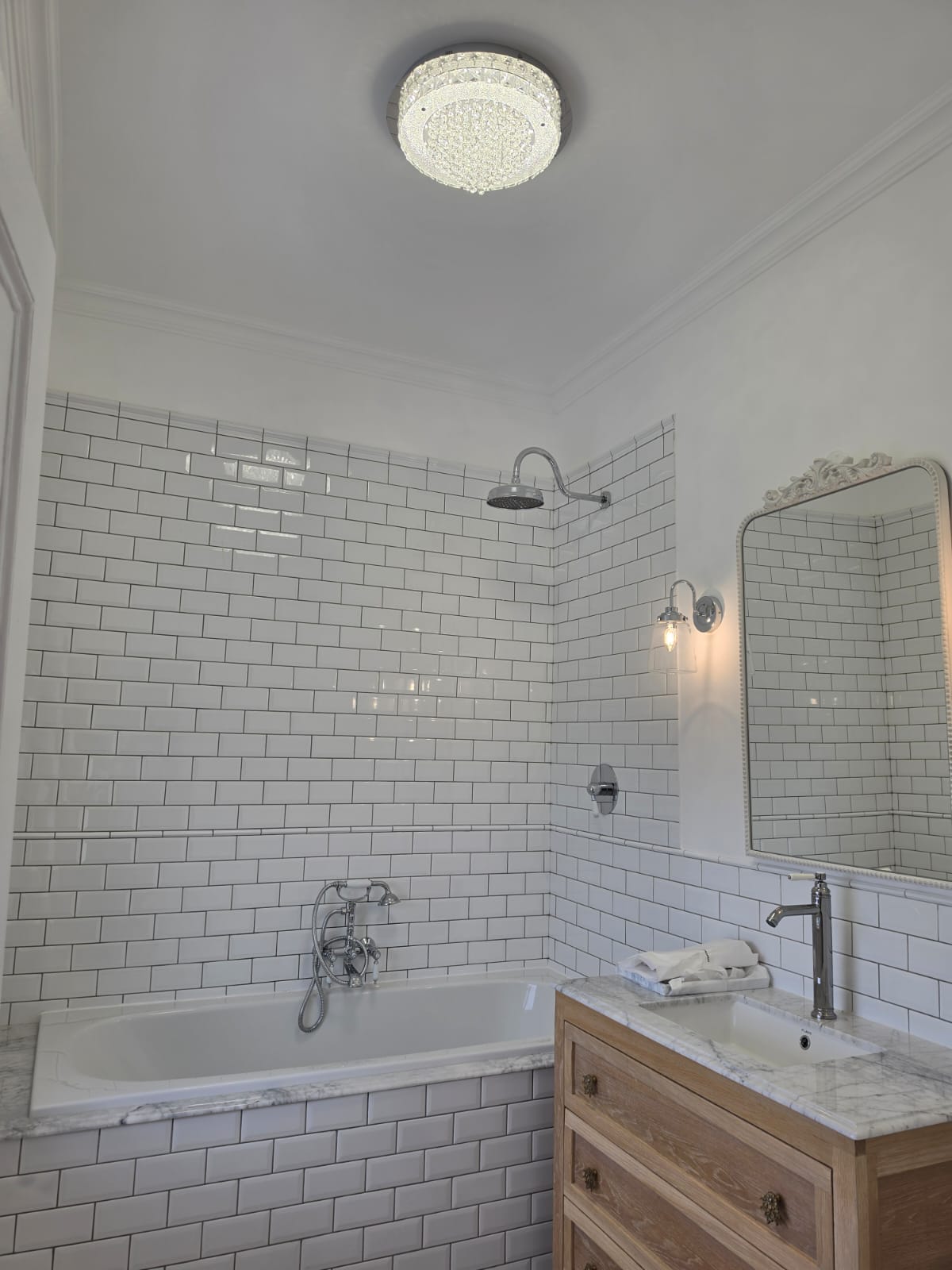 Completed bathroom with rainfall shower, bath mixer and vanity basin