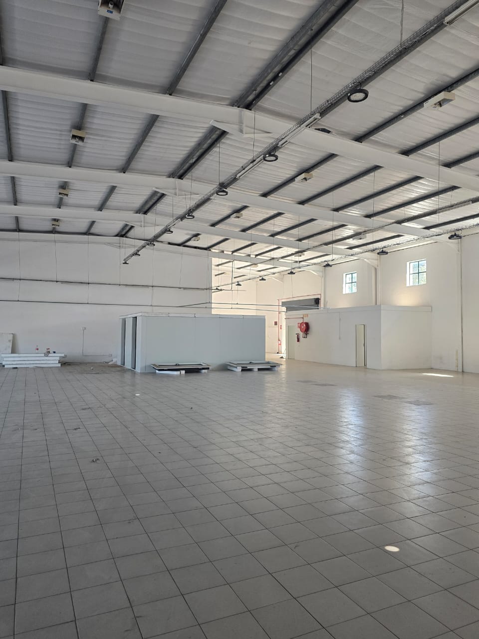 Empty warehouse unit with exposed steel roof structure and no ceiling installed