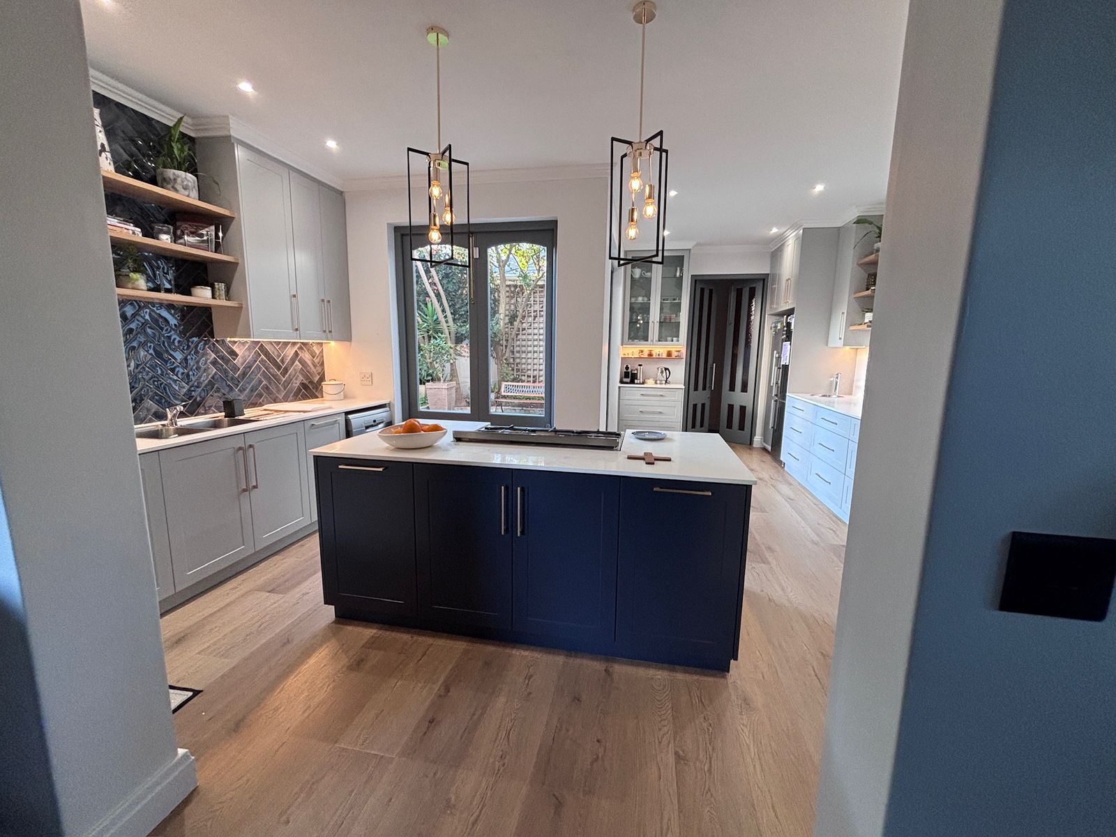 Wide-plank laminate flooring running through a renovated open-plan kitchen